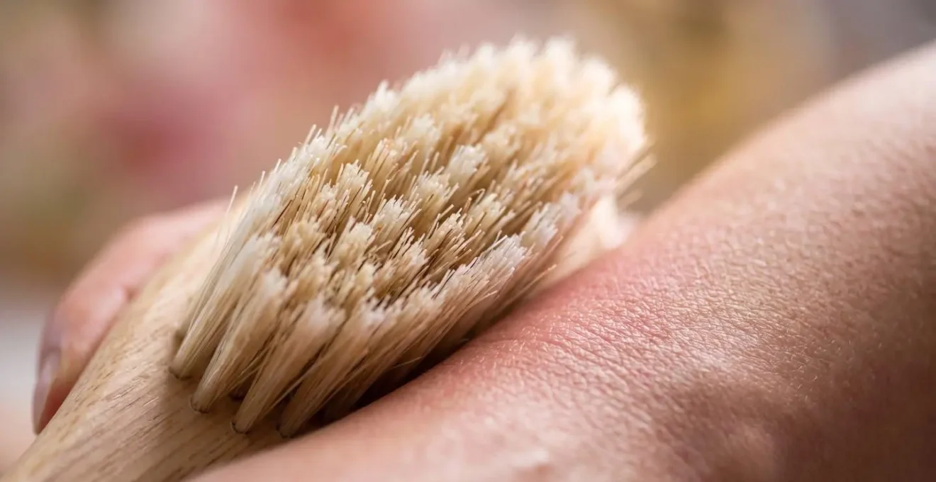 Dettaglio macro di spazzola con setole naturali su pelle con texture visibile, effetto drenante